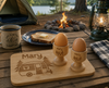 Personalised camping breakfast set featuring a custom engraved bamboo chopping board and matching egg cup, perfect for caravans, camping trips and outdoor adventures.