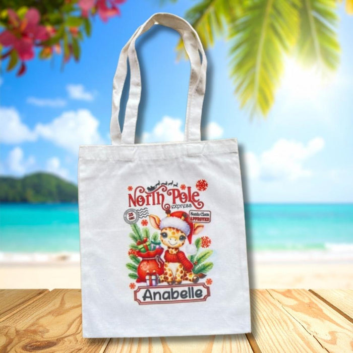 Personalised Christmas tote bag featuring a festive giraffe with Christmas gifts and personalised name.