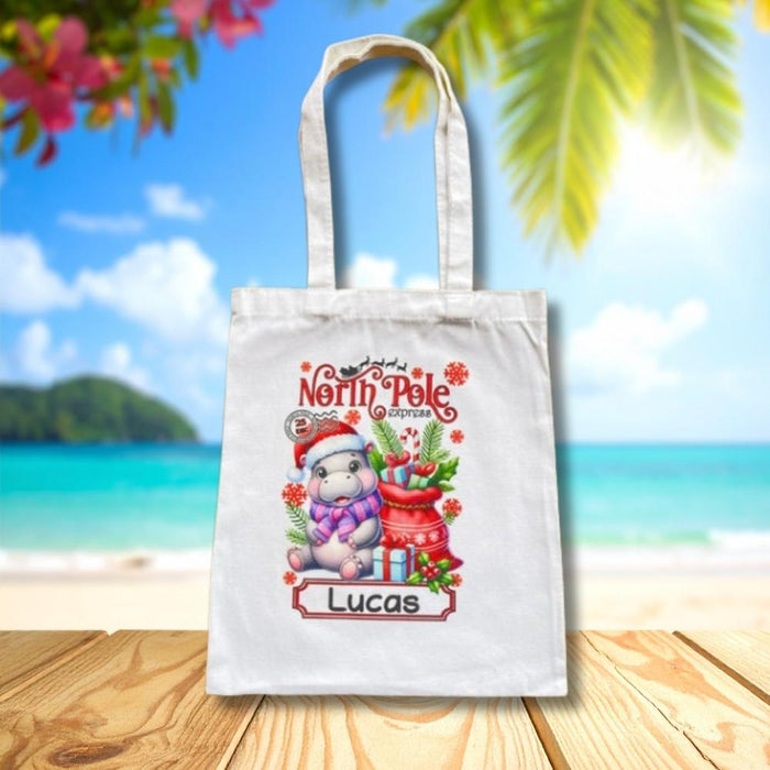 Personalised Christmas tote bag featuring a Christmas hippo and presents with custom child name.