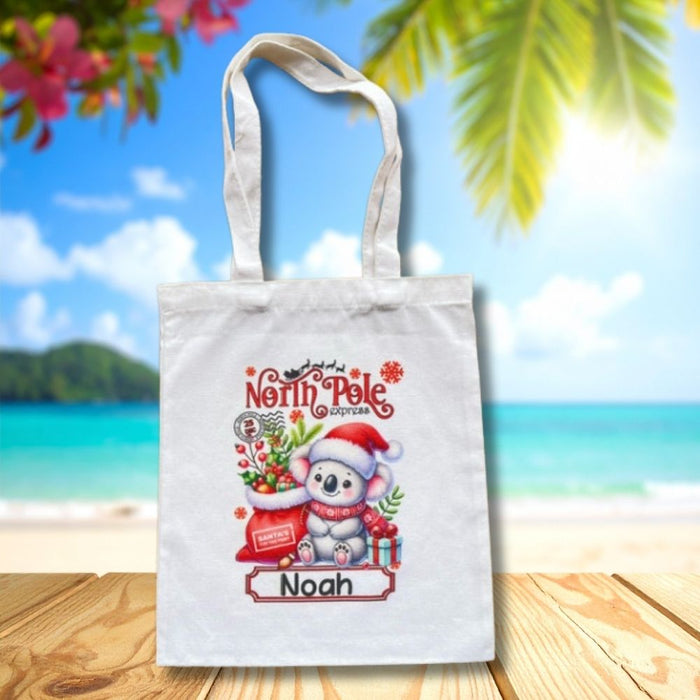 Personalised Christmas tote bag featuring a Christmas koala and presents with custom child name.