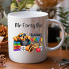 A white ceramic mug with a custom printed design featuring a cartoon dog wearing sunglasses and a black t-shirt that reads 'I TEACH TRICKS I CHILL'. The design includes colorful books, a heart-shaped mug, and text that says 'TEACHERS MAKE THE WORLD BRIGHTER PLACE' and 'Mr Forsythe'.