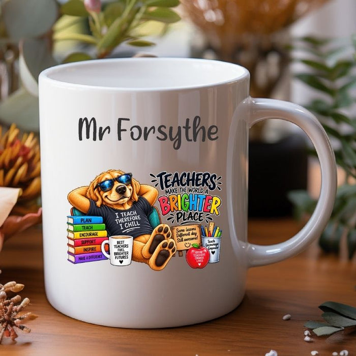 A white ceramic mug with a custom printed design featuring a cartoon dog wearing sunglasses and a black t-shirt that reads 'I TEACH TRICKS I CHILL'. The design includes colorful books, a heart-shaped mug, and text that says 'TEACHERS MAKE THE WORLD BRIGHTER PLACE' and 'Mr Forsythe'.