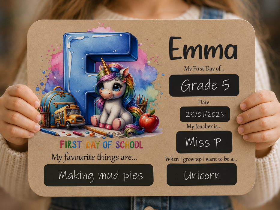 A person holds a personalized first-day-of-school sign featuring a cartoon unicorn, school supplies, and chalkboard-style text fields for the name Emma, grade 5, date, teacher, favorite thing, and future goal.