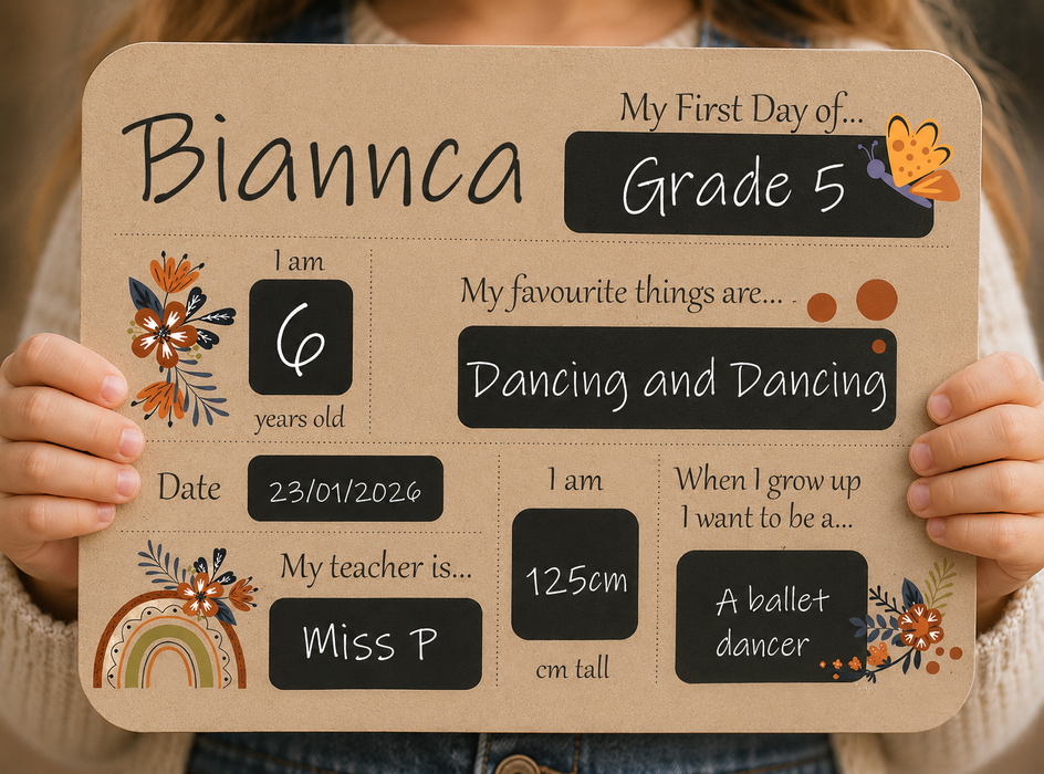 A child holds a personalized first-day-of-school sign personalised, Grade 5, and fill-in boxes for age, favorite things, date, height, teacher, and aspirations. The sign has a warm tan background with black text boxes and small orange, brown, and blue floral illustrations.